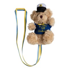 Studentnalle Beige med Tröja – söt nalle med studentmössa, blå tröja och gul rosett. Perfekt att hänga runt halsen på studenten eller ge som present.